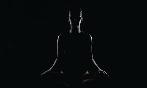Lady meditating in dark room 