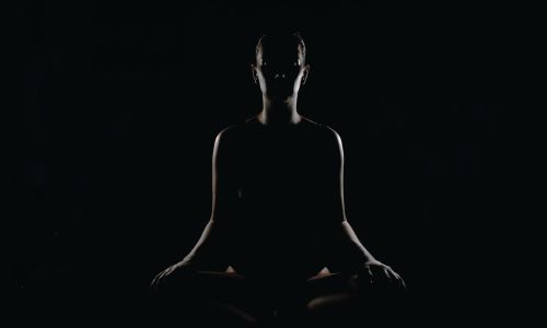 Lady meditating in dark room